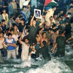 يتجمع ليبيون مبتهجون في مياه خزانٍ افتتحه الزعيم الليبي العقيد معمر القذافي -قرابة 28 أغسطس 1991- في إطار مشروع "النهر الصناعي العظيم" للري، الذي ينقل المياه من خزانات جوفية في الصحراء الجنوبية إلى المناطق الساحلية المأهولة بالسكان. (صورة من أسوشيتد برس/ سانتياغو ليون)