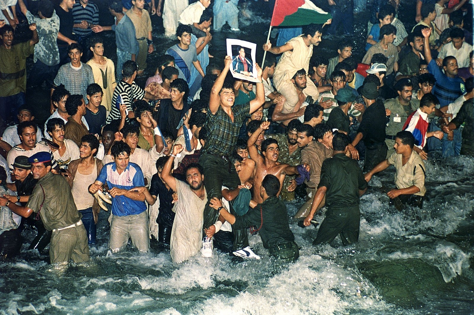 يتجمع ليبيون مبتهجون في مياه خزانٍ افتتحه الزعيم الليبي العقيد معمر القذافي -قرابة 28 أغسطس 1991- في إطار مشروع "النهر الصناعي العظيم" للري، الذي ينقل المياه من خزانات جوفية في الصحراء الجنوبية إلى المناطق الساحلية المأهولة بالسكان. (صورة من أسوشيتد برس/ سانتياغو ليون)